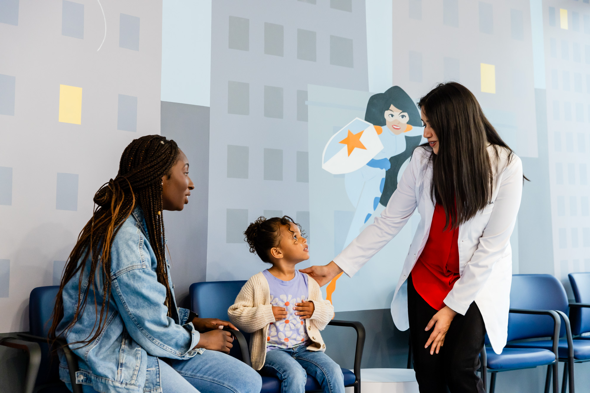 Pediatric dentist in Gainesville talking to a young patient and her mom